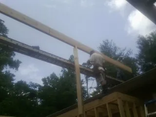 Carpenter setting a ridge beam over a new addition frame — Ice Dam Removal by Roofing Brothers in Rachel