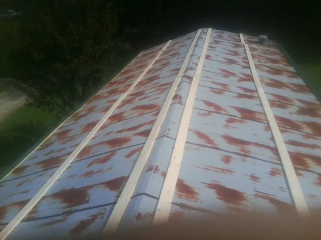 Rusted metal roof panels with new wood purlins before replacement — Storm Damage Roof Repair in Rachel by Roofing Brothers