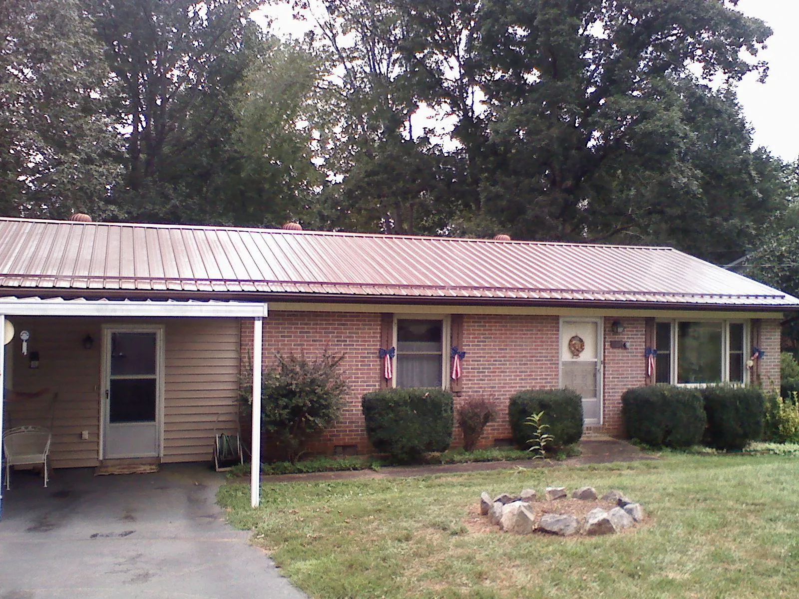 Bronze metal roof and carport on a brick ranch home — Roof Repair work by our crew in Rachel